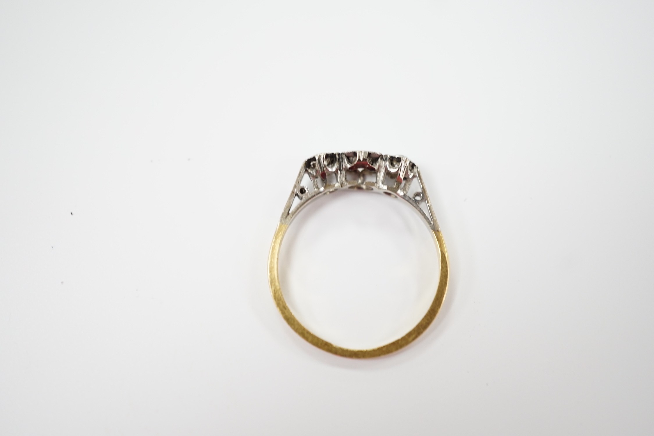 An 18ct, plat and three stone diamond set ring, size N/O, gross weight 2.1 grams.